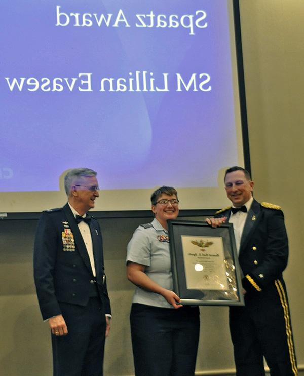 Three people in uniform at awards presentation